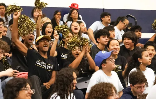 Quixilver students in team shirts cheering in the stands